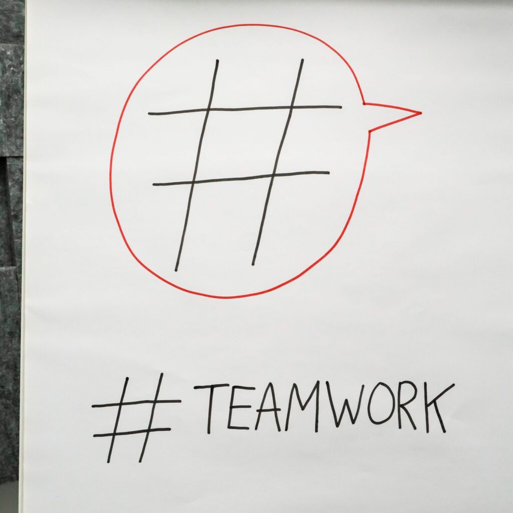 A poster in an office setting highlighting teamwork with a hashtag symbol.