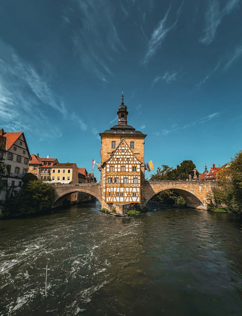 Stunning daytime view of Bamberg's Altes Rathaus on the river, showcasing traditional German architecture.